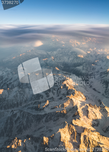 Image of Mountains and clouds at sunset view from plane