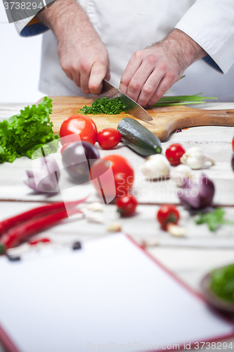 Image of Chef cutting a green parsley his kitchen