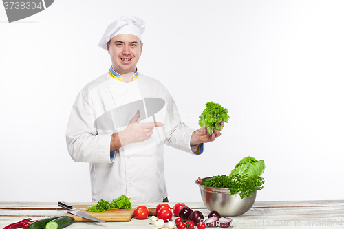 Image of Chef cooking fresh vegetable salad in his kitchen