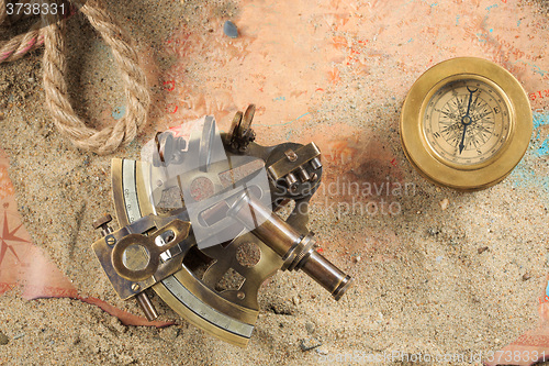 Image of set of nautical instruments, lying on the sand and old map. concept adventure