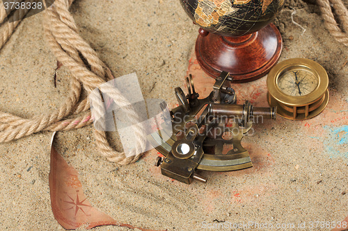 Image of set of nautical instruments, lying on the sand and old map. concept adventure