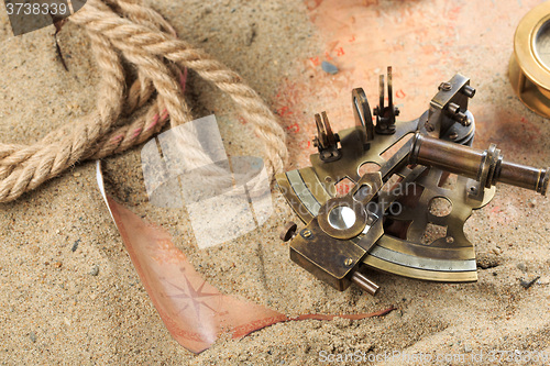 Image of set of nautical instruments, lying on the sand and old map. concept adventure
