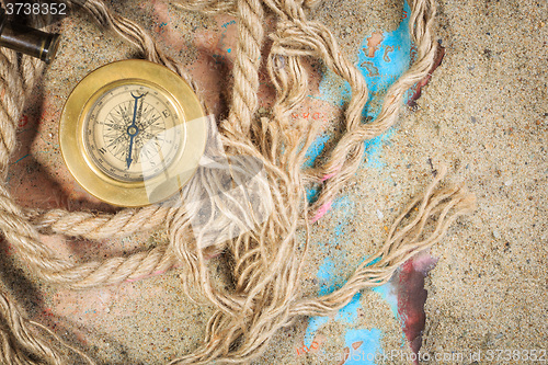 Image of set of nautical instruments, lying on the sand and old map. concept adventure