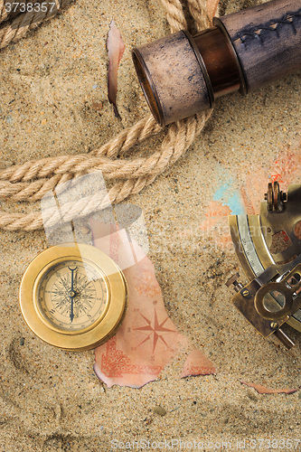 Image of set of nautical instruments, lying on the sand and old map. concept adventure