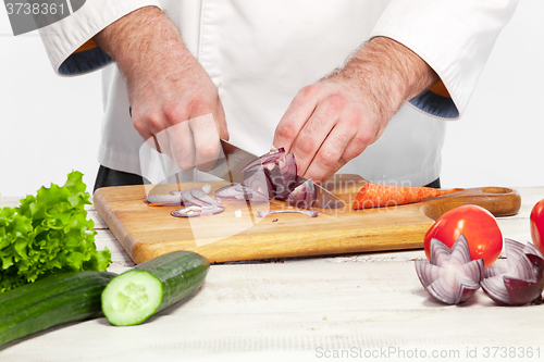 Image of Chef cutting a onion on his kitchen