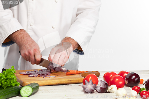 Image of Chef cutting a onion on his kitchen