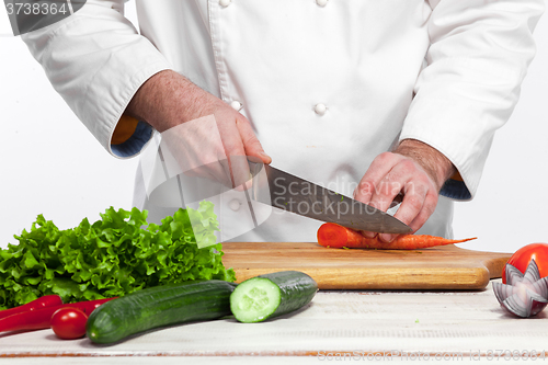 Image of Chef cooking fresh vegetable salad in his kitchen