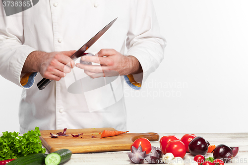Image of Chef cooking fresh vegetable salad in his kitchen