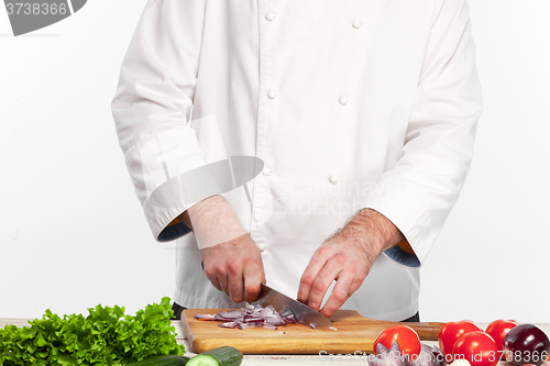 Image of Chef cutting a onion on his kitchen