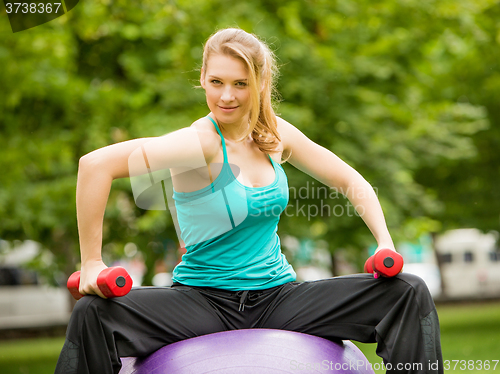 Image of Sports girl  exercise with dumbbells in the park
