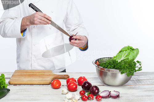 Image of Chef cooking fresh vegetable salad in his kitchen