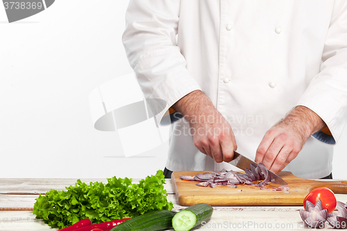 Image of Chef cutting a onion on his kitchen