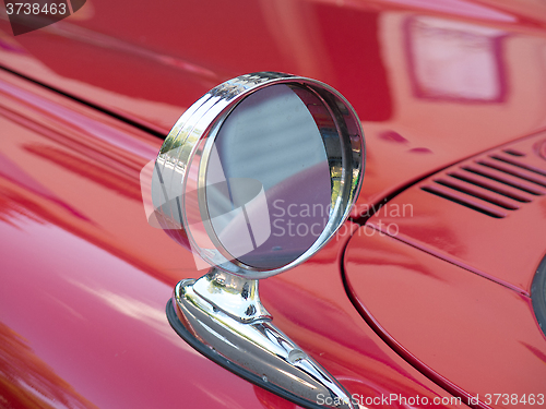 Image of one side mirror on a red car