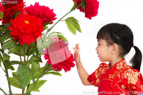 Image of Chinese little girl wearing in Red posing with flowers