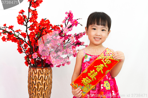 Image of Chinese little girl pising holding  Spring festival couplets