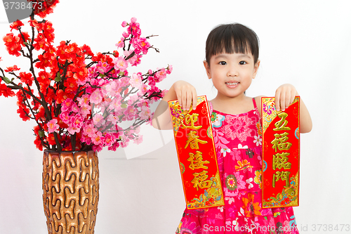 Image of Chinese little girl pising holding  Spring festival couplets