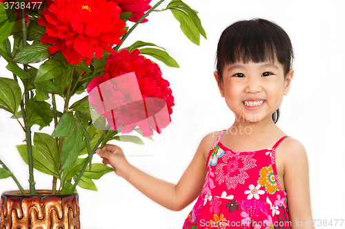 Image of Chinese little girl wearing in Red posing with flowers