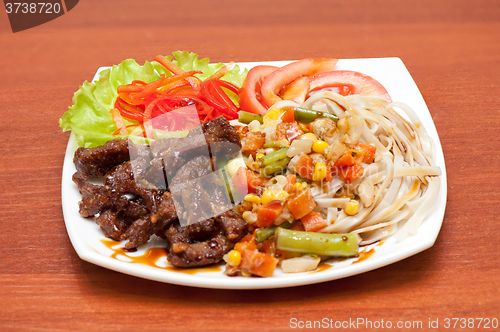 Image of chinese noodles with roasted meat and vegetables