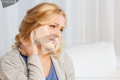 Image of unhappy woman suffering from neck pain at home