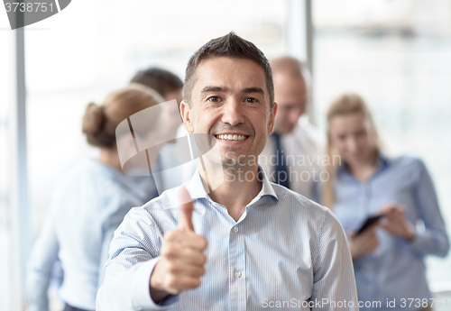 Image of group of smiling businesspeople meeting in office