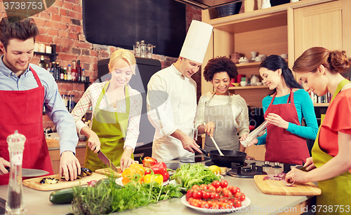 Image of happy friends and chef cook cooking in kitchen