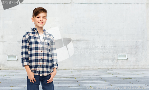 Image of smiling boy in checkered shirt and jeans