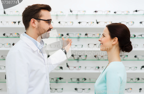 Image of woman and optician showing glasses at optics store