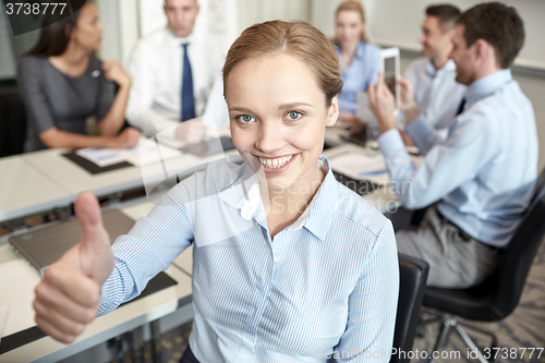 Image of group of smiling businesspeople meeting in office