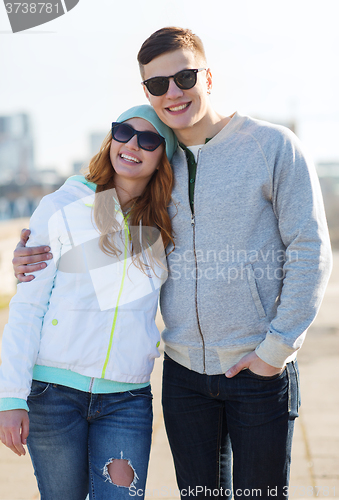 Image of happy teenage couple walking in city