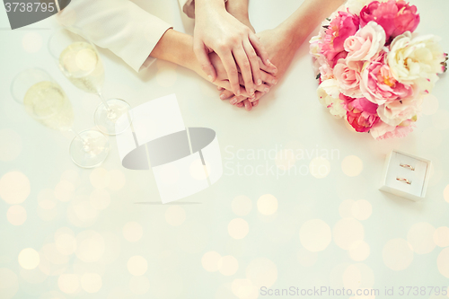 Image of close up of lesbian couple hands and wedding rings