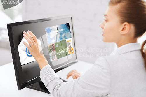 Image of woman with web pages on touchscreen in office