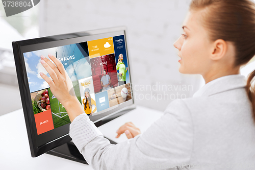 Image of woman with web pages on touchscreen in office