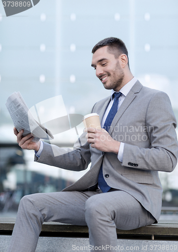 Image of young businessman with coffee and newspaper