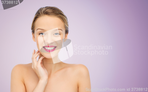 Image of smiling young woman with pink lipstick on lips