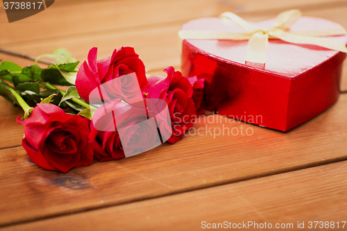 Image of close up of heart shaped gift box and red roses