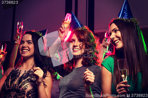 Image of smiling friends with glasses of champagne in club