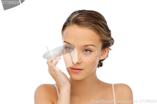 Image of young woman applying cream to her face