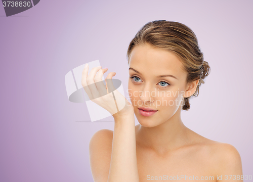 Image of woman smelling perfume from wrist of her hand