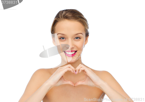 Image of smiling young woman showing heart shape hand sign