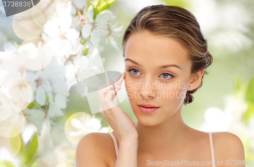 Image of young woman applying cream to her face