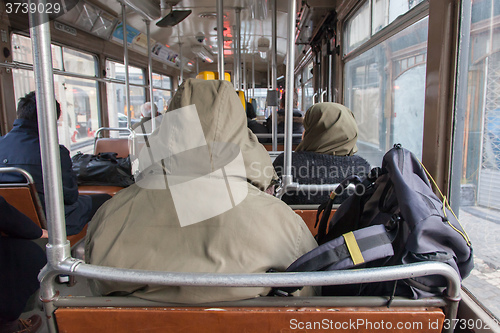 Image of Man in winter coat sitting in tram