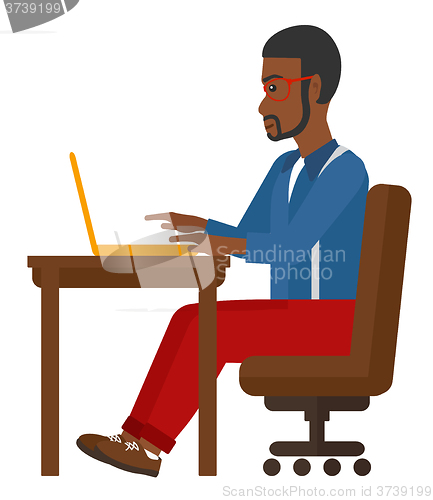Image of Man working at laptop.