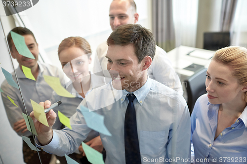 Image of smiling business people with marker and stickers