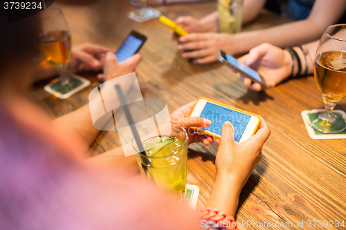 Image of close up of hands with smartphones at restaurant