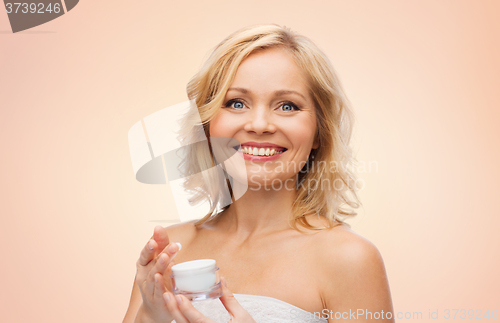 Image of happy middle aged woman with cream jar