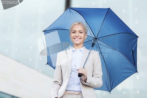 Image of young smiling businesswoman with umbrella outdoors