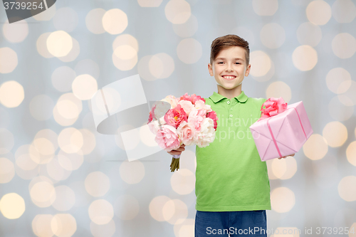 Image of happy boy holding flower bunch and gift box