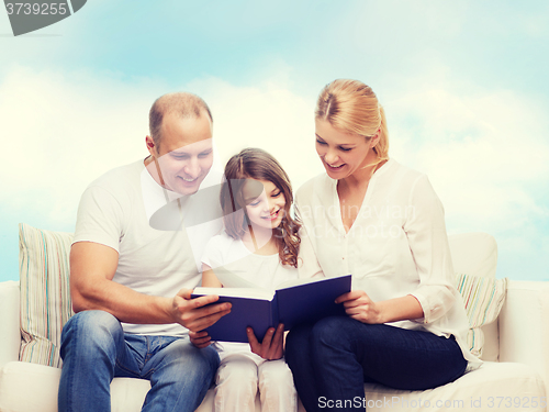 Image of happy family with book at home