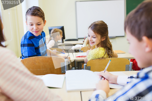 Image of group of school kids writing test in classroom