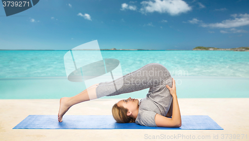 Image of woman making yoga in plow pose on mat